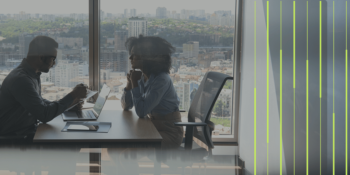 Modern business environment with a man and woman in front of window facing a city
