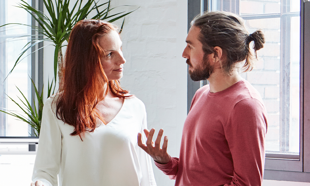 A man and a woman discussing work in the office.