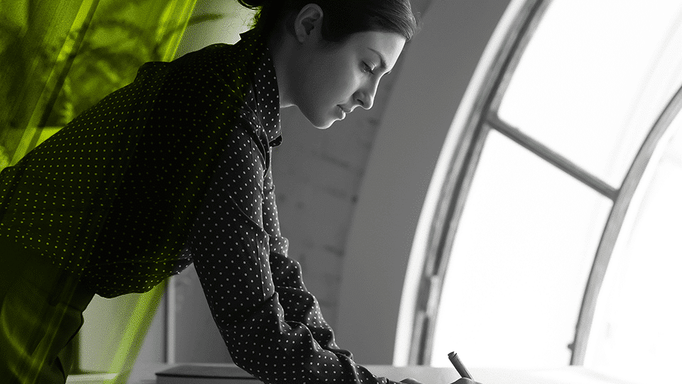 Female consultant standing and writing on a desk