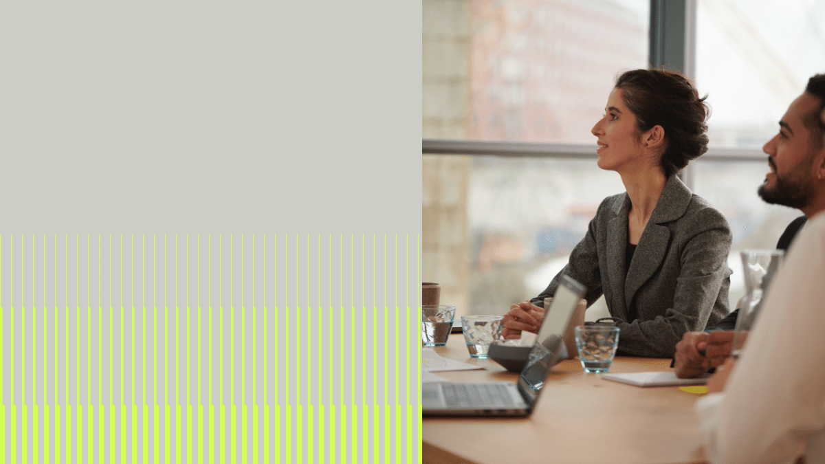 Two young professionals sitting in a meeting.